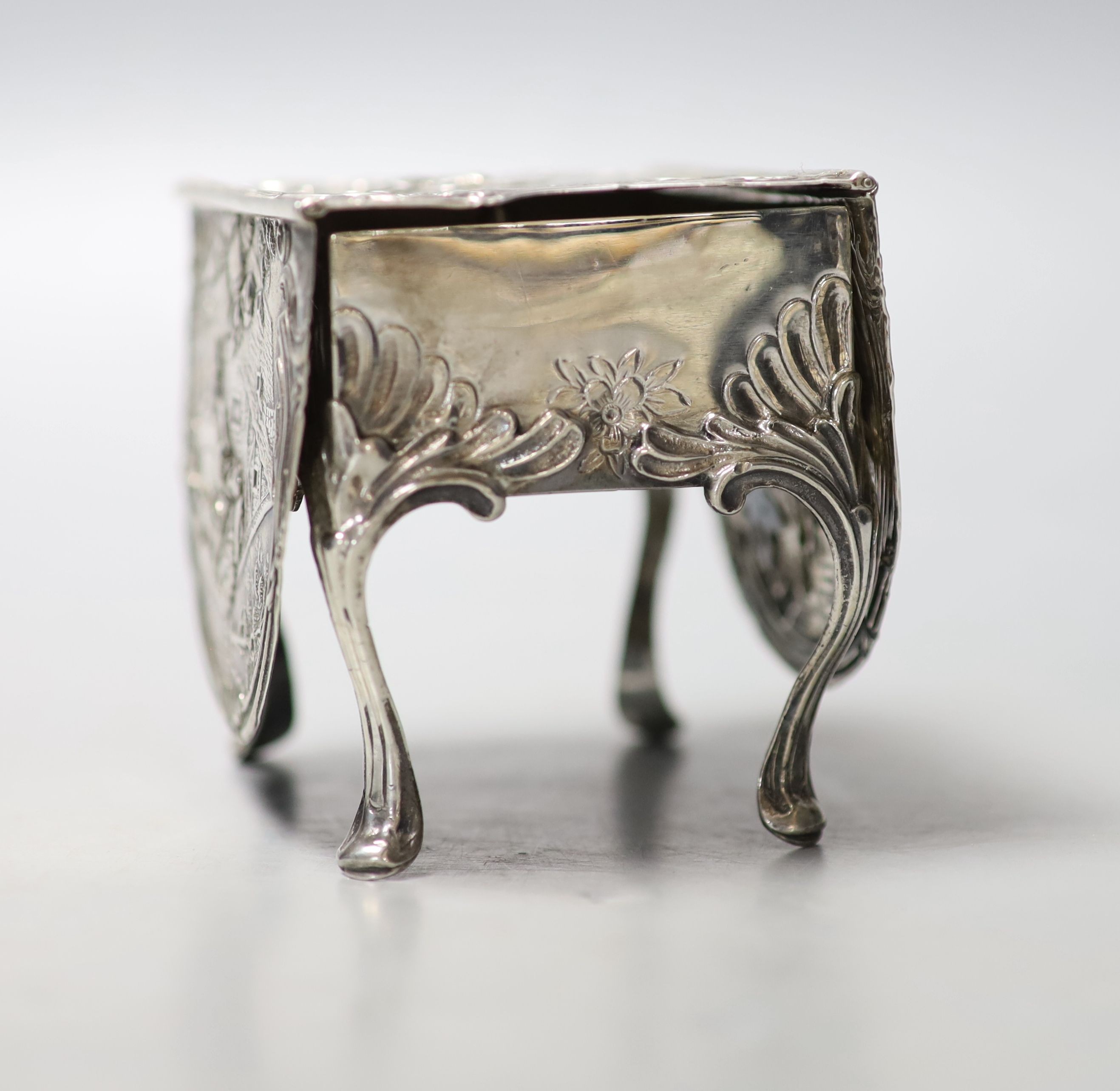 A late 19th century Hanau repousse silver miniature model of a drop flap table, import marks for Chester, 1898, height 71mm, 185 grams.